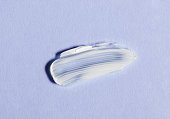 White skin cream smear on violet background