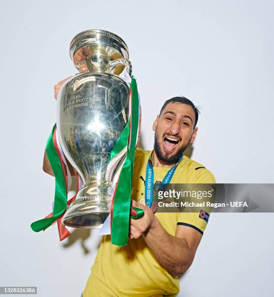 Gianluigi Donnarumma of Italy poses with The Henri Delaunay Trophy during an Italy Portrait Session following their side's victory in the UEFA Euro...