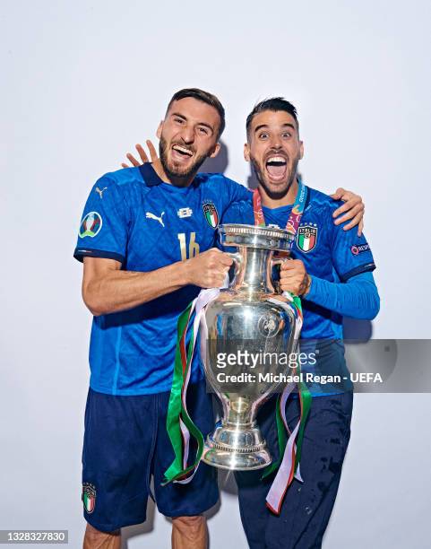 Bryan Cristante and Leonardo Spinazzola of Italy pose with The Henri Delaunay Trophy during an Italy Portrait Session following their side's victory...