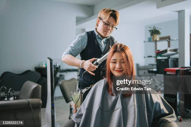 asian chinese female beautician hairdresser using hair curler setting fashion hairstyle in beauty hair salon - black hair stylist stock pictures, royalty-free photos & images