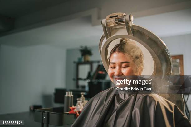 asian chinese female getting her hair steaming and moisturizing treatment in hair salon - hair salon imagens e fotografias de stock