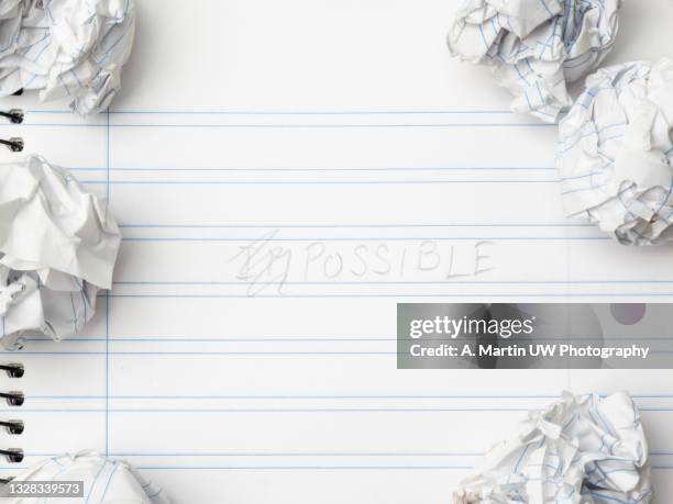 notebook with the word "possible" written on it and several balls of crumpled paper. - lijntjespapier stockfoto's en -beelden
