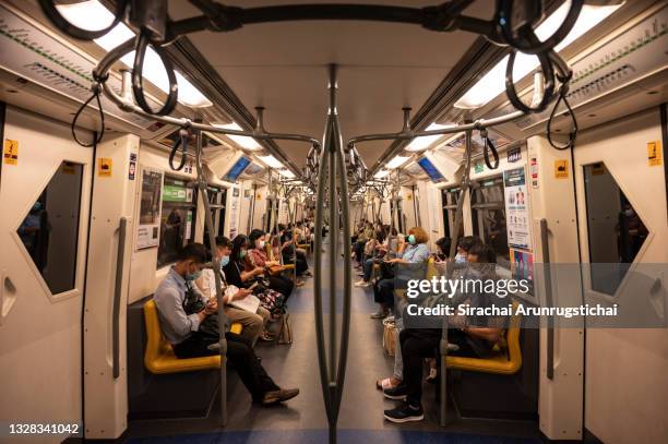 People in face masks are seen riding the BTS Skytrain during rush hour before the curfew on July 12, 2021 in Bangkok, Thailand. Thailand reported...