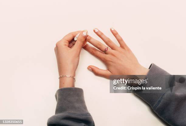 hands of  young woman removing nail polish against white background - enamel stockfoto's en -beelden