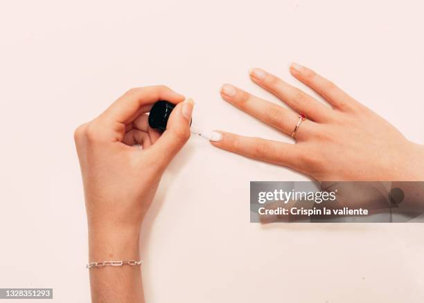 young woman hands painting nails with white polish, on white background, close-up - white nail polish fotografías e imágenes de stock