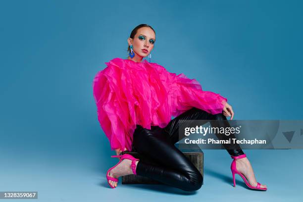 beautiful woman wearing pink top and leather pants - warm roze stockfoto's en -beelden