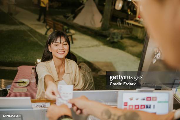 junges thailändisches mädchen, das nach der essensbestellung bar bezahlt - stockfoto - boy thailand stock-fotos und bilder