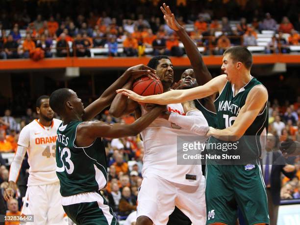Fab Melo of the Syracuse Orange fights for the rebound against Donovan Kates, Ryan McCoy and George Beamon of the Manhattan College Jaspers during...