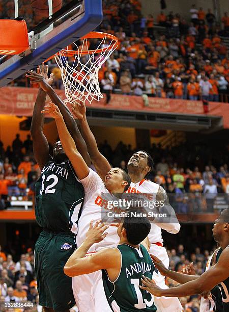 Michael Carter-Williams of the Syracuse Orange drives up to the basket with the help of teammate Fab Melo while being blocked by Rhamel Brown and...