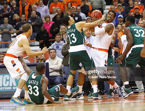 Fab Melo of the Syracuse Orange fights to maintain possession against Emmy Andujar of the Manhattan College Jaspers during the NIT Season Tip-off...