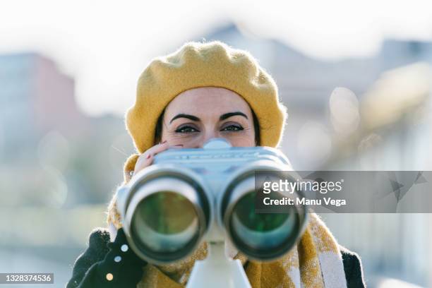 woman using telescopic viewer - vinden stockfoto's en -beelden