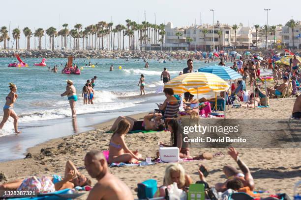 People enjoy the hot weather at the beach on July 12, 2021 in Torremolinos, Málaga, Spain. Malaga currently sees a yellow warning for temperatures...