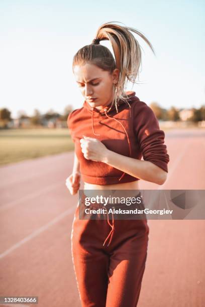 sportswoman enjoying competitive running on track - toughness stock pictures, royalty-free photos & images