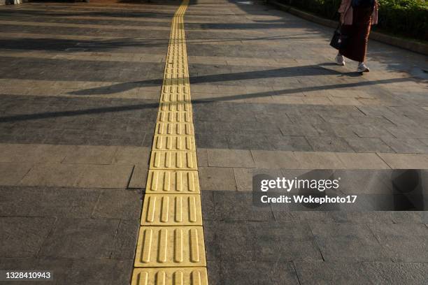 yellow tactile paving for blind people - braille foto e immagini stock