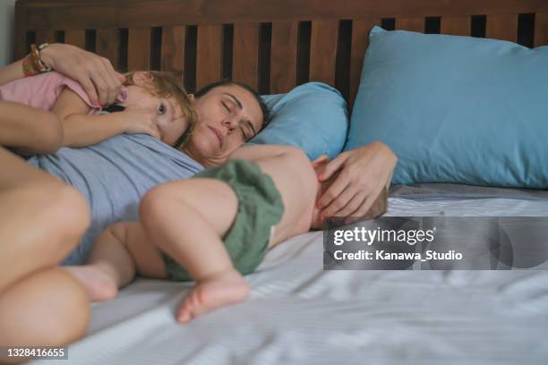 tired mom sleeping with her kids - child sleep insomnia stock pictures, royalty-free photos & images