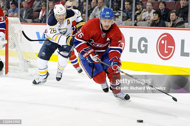 Josh Gorges of the Montreal Canadiens skates with the puck while being followed by Thomas Vanek of the Buffalo Sabres during the NHL game at the Bell...