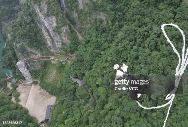 Tourist experiences bungee jumping at the Zhangjiajie Grand Canyon scenic area on July 12, 2021 in Zhangjiajie, Hunan Province of China.