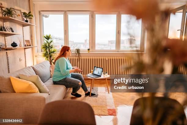 woman video conferencing with doctor on laptop - stay at home saying stock pictures, royalty-free photos & images