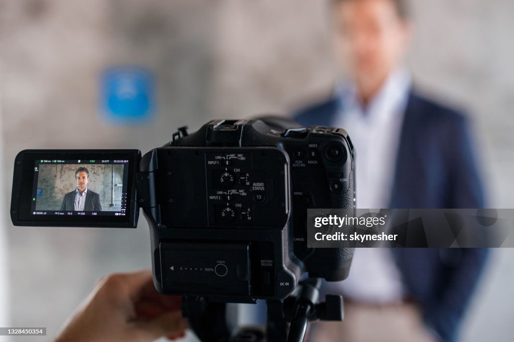 Close up of a camera filming male entrepreneur.