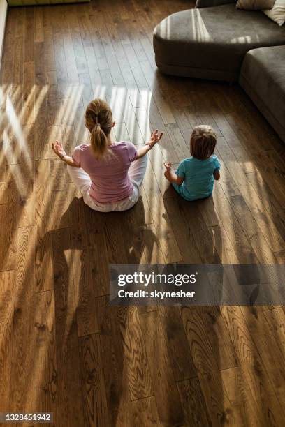 above view of single mother and son meditating in the living room. - child yoga elevated view stock pictures, royalty-free photos & images