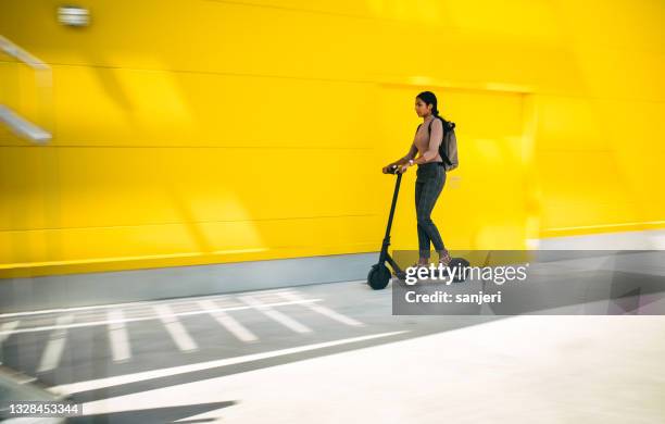 joven empresaria que conduce un scooter eléctrico - mobility scooter fotografías e imágenes de stock