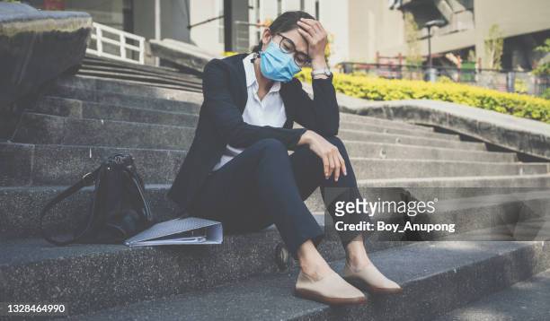 unemployed businesswoman having stressed after failure and laid off from work because impact from covid-19 pandemic outbreak and economic depression. - epidemie stock-fotos und bilder