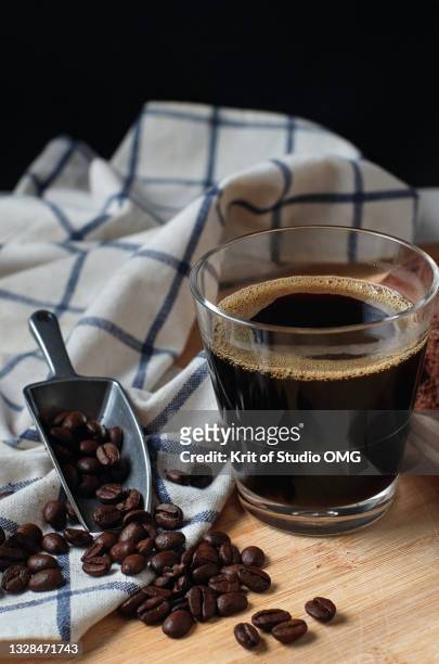 a cup of black coffee with roasted coffee beans - americano photos et images de collection