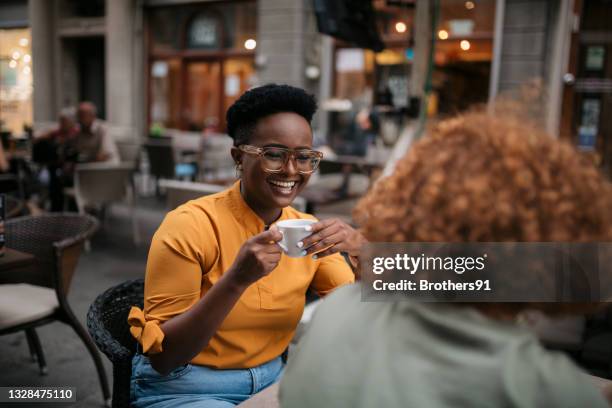 small diverse group of female friends sitting in a coffee shop - friends talking cafe stock pictures, royalty-free photos & images