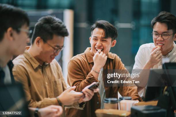 4 asian chinese eating popcorn waiting for movie show time at bar counter lobby lounge beside ticketing counter in cinema movie theater - digital devices beside each other stockfoto's en -beelden