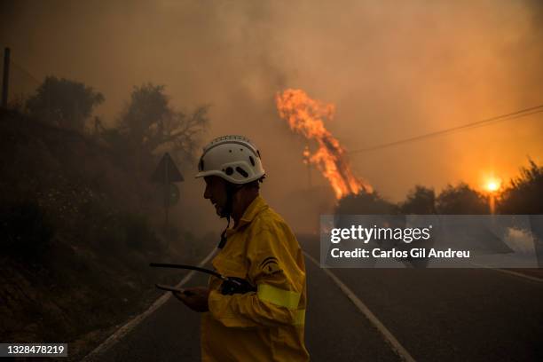 Firefighter passes by a road during a fire in the Granada area on July 12, 2021 in Granada, Spain. A fire in an area between Granada, Jun and Viznar...