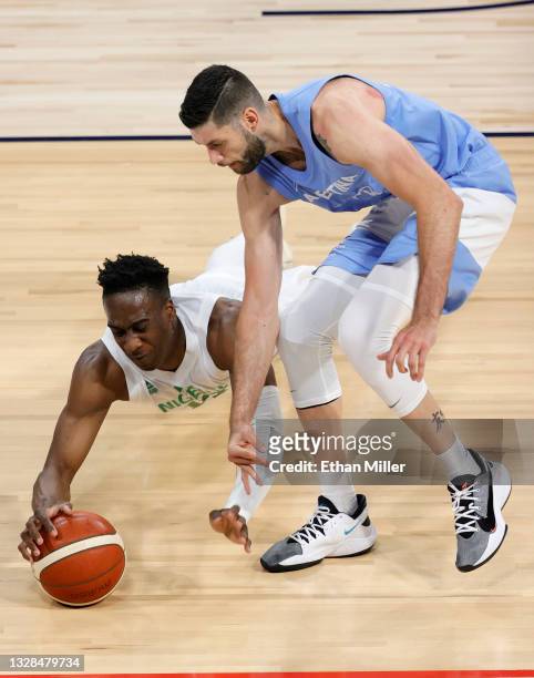 Miye Oni of Nigeria and Patricio Garino of Argentina go after a loose ball during an exhibition game at Michelob ULTRA Arena ahead of the Tokyo...
