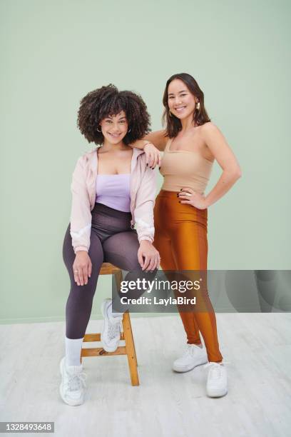 retrato de estudio de cuerpo completo de dos jóvenes posando sobre un fondo verde - chicas gorditas fotografías e imágenes de stock