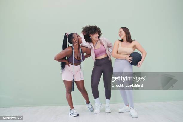 full body studio shot of a group of young woman posing in gym wear against a green background - friends studio shot stock pictures, royalty-free photos & images