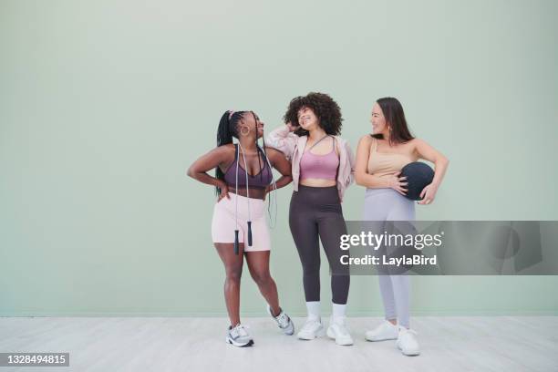 ganzkörper-studioaufnahme einer gruppe junger frauen, die in turnkleidung vor grünem hintergrund posieren - man standing full body stock-fotos und bilder