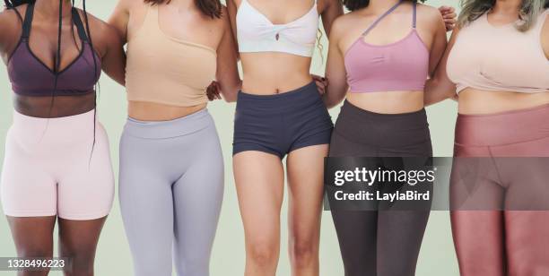 cropped studio shot of a group of unrecognizable women embracing each other against a green background - fat legs stock pictures, royalty-free photos & images