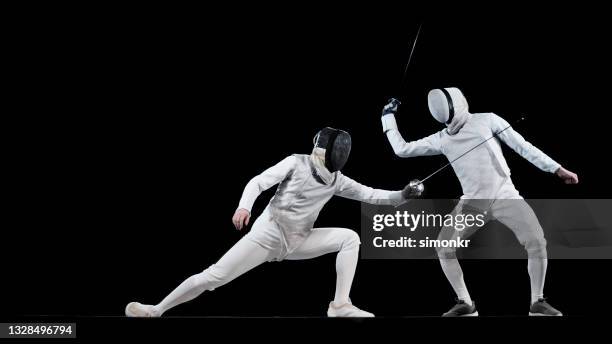 fencing athletes competing . - man with sword front stock pictures, royalty-free photos & images