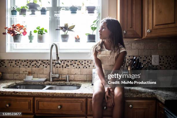 portrait of young girl in kitchen at home - innocence project stock pictures, royalty-free photos & images