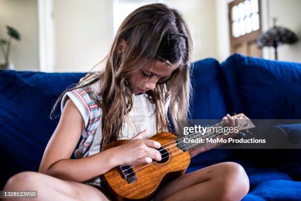 young girl playing ukulele at home - ukelele stock pictures, royalty-free photos & images