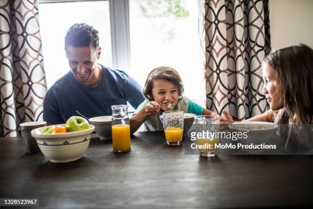 father having breakfast with children - orange juice glass white background stock pictures, royalty-free photos & images