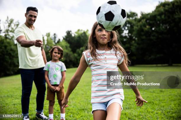 young girl playing soccer at park - georgia football stockfoto's en -beelden