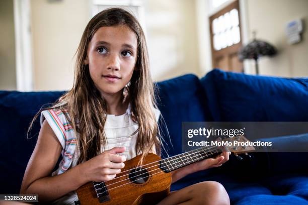 young girl playing ukulele at home - blues musicians stock pictures, royalty-free photos & images