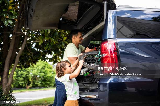 father and son loading bicycles into car - car trunk - fotografias e filmes do acervo