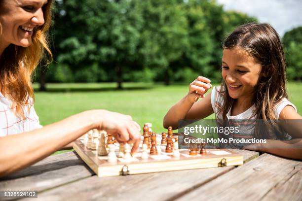 mother and daughter playing chess at public park - picnic table park stock pictures, royalty-free photos & images