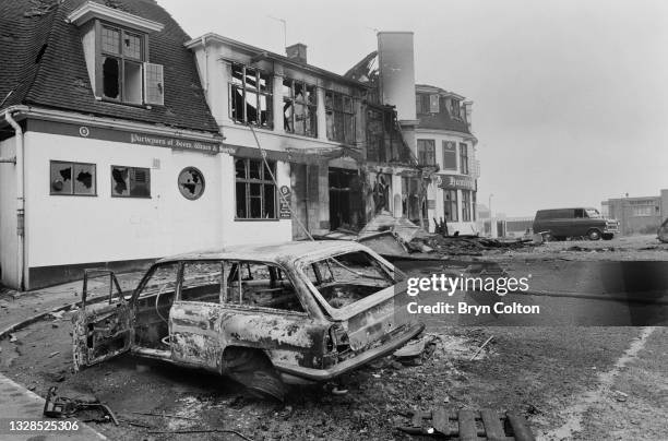 Fire damaged vehicles outside the burnt-out public house the Hambrough Tavern, after the building was set on fire during a night of rioting in...