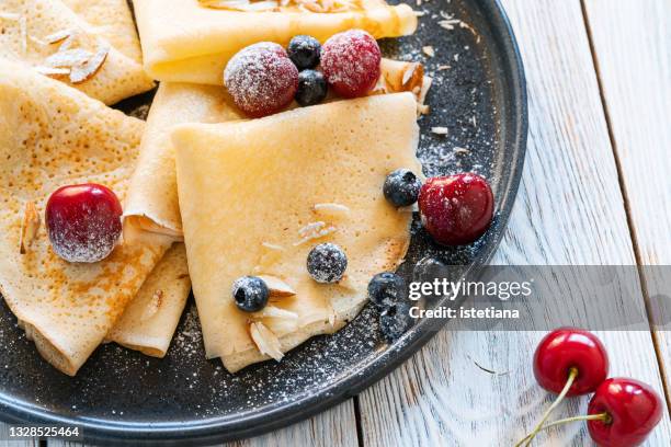 crepes with fresh summer sweet berries, sugar powder and almonds, close up - icing sugar stock pictures, royalty-free photos & images