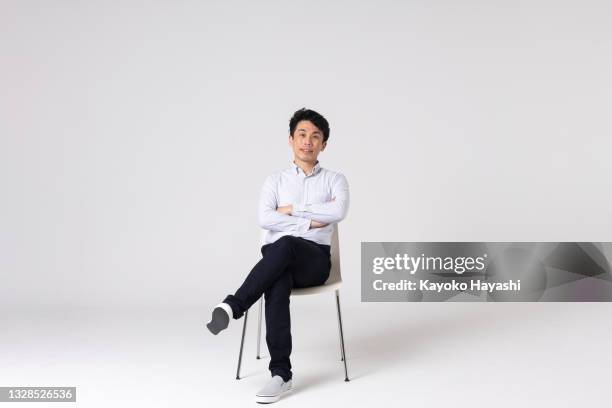 full-length portrait of an asian man on a white background. - white chair isolated stock pictures, royalty-free photos & images