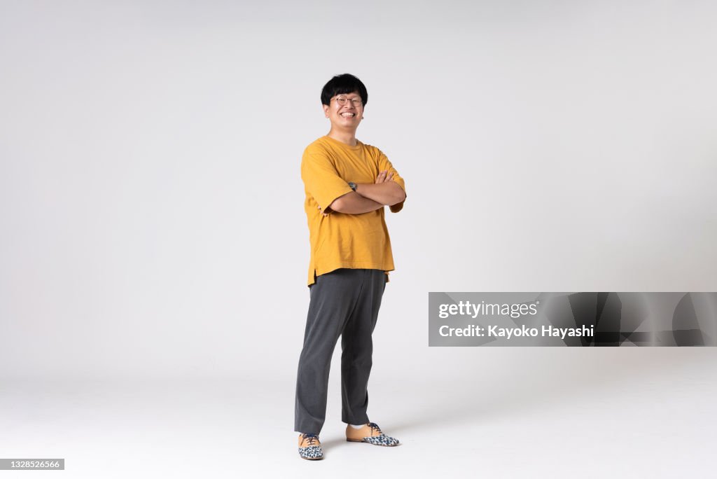 Full-length portrait of an Asian man on a white background.