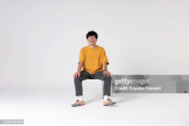 ritratto a figura intera di un uomo asiatico su sfondo bianco. - sedersi posizione fisica foto e immagini stock