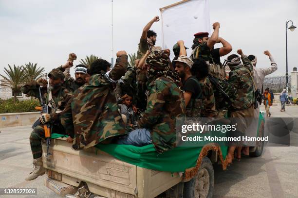 Houthi followers shout slogans as they ride a truck carrying the coffin of a fighter who was killed in the recently intensified fighting in Al-Bayda...