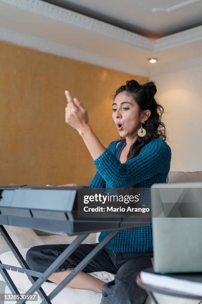 latin woman teaches piano and vocal technique classes remotely through the laptop - professional musician stock pictures, royalty-free photos & images